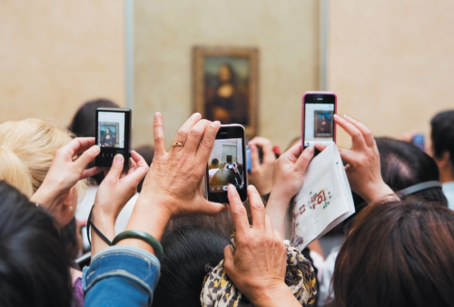 Museumgoers taking photographs of the <i>Mona Lisa</i> at the Louvre, Paris, 2012