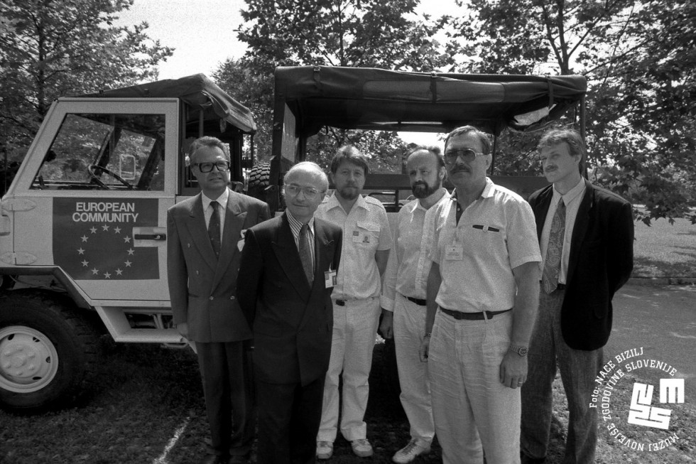 				Med predstavniki slovenskega zunanjega ministrstva in misije Evropske skupnosti je krožil predlog, da bi Slovenija postala &raquo;case study&laquo; Evropske skupnosti (na fotografiji opazovalci EU na obisku v Sloveniji julija 1991). | Avtor Nace Bizilj, hrani: Muzej novej&scaron;e zgodovine Slovenije			