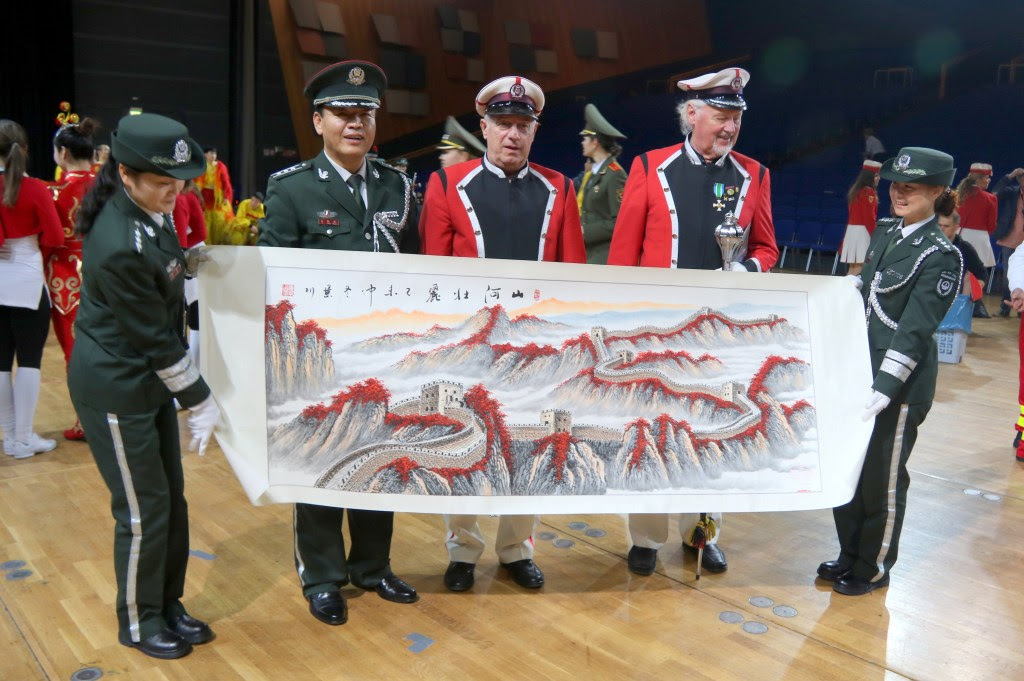 
				Sodelovanja na MUSIKPARADE so omogočali tudi navezovanje stikov z orkestri iz raznih koncev sveta. Z vodstvom vojaškega orkestra iz Kitajske sva s predsednikom poštnega orkestra Ivom Jurišičem izmenjala spominska darila. Fotografija: arhiv E. Hartmana			